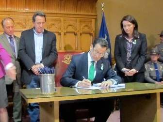 Gov. Dannel P. Malloy, shown here signing the Sandy Hook bill into law as parents of victims watch.