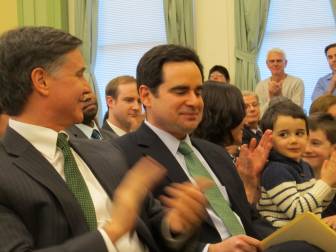 Robert Klee accepts the applause of his mentor and boss, Daniel C. Esty. At right, are his wife, Anne, and sons, Alex and Jacob.