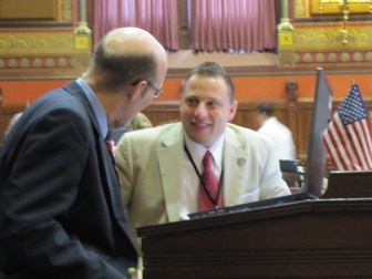 Rep. Rob Sampson, R-Wolcott, consults with Sen. Joe Markley during a House debate