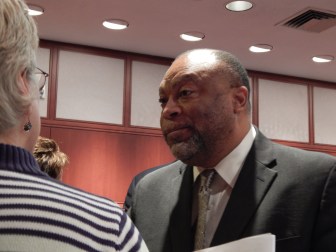 This is a photo of Roderick L. Bremby, Connecticut's social services commissioner, speaking to a social worker.