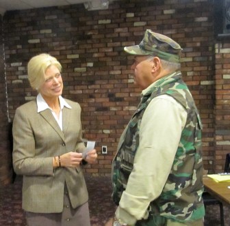 Martha Dean, holding contribution checks, chats with a line of well-wishers after speaking to gun owners.