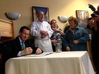 Gov. Dannel P. Malloy signs the minimum wage bill into law.
