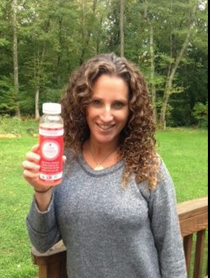 Tara Cook-Littman, holding a GMO-free beverage that produces revenue for the campaign set labeling standards for genetically modified foods. 