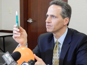 This is a photo of Griffin Hospital CEO Patrick Charmel holding up the type of insulin pen that was misused, potentially exposing patients to disease transmission.