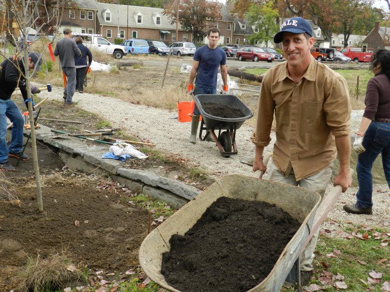 Alex Felson working with volunteers helping to plant the Seaside Village rain garden.