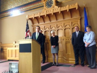 The governor defends his budget -- and record. At right, House Majority Leader Joseph Aresimowicz and Sen. Beth Bye watch.