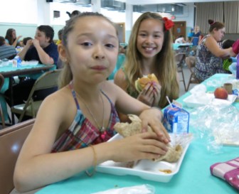Maysalee Gray-Khen (left), 7, and Monysohn Gray-Khen (right), 9, enjoy their lunch at Ellington's Summer Meal program, at St. Joseph's Church.