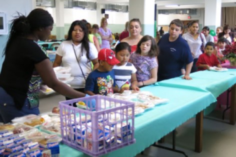 Children and their parents line up to receive meals.