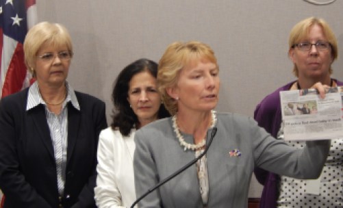 Rep. Pam Sawyer (foreground) shows headline about infant death in EH. Reps. Tami Zawistowski and Gail Lavielle and Sen. Cathy Osten (L to R) in background.