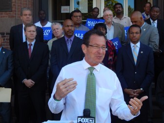 Gov. Dannel P. Malloy unveils urban jobs initiatives outside Faith Congregational Church in Hartford. (Civic and municipal leaders in background)