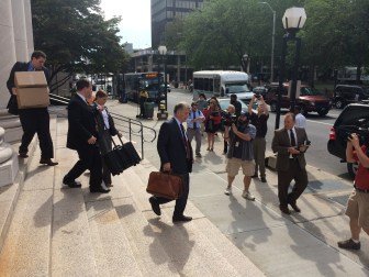 Rowland's legal team leaving court earlier in trial. At center is Reid H. Weingarten.