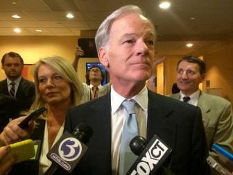 Foley talks to reporters after the debate. At left is his running mate, Heather Bond Somers.