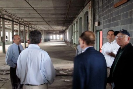 Gov. Dannel P. Malloy, Connecticut U.S. Sen. Richard Blumenthal, backs to camera, and then-U.S. Interior Secretary Ken Salazar, left, on a tour of the Colt Armory with developers in September 2011.