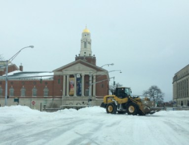 A payloader clears snow on Capitol Avenue in Hartford at midday Tuesday before the travel ban was lifted.