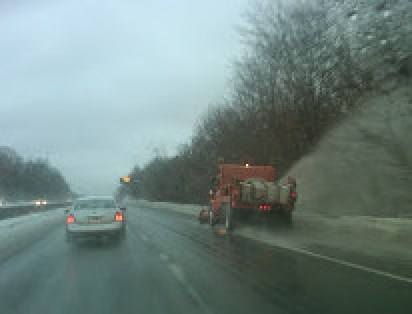 A Connecticut DOT truck plowing and treating a highway.