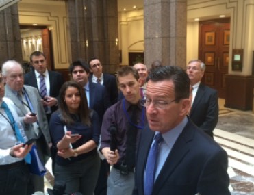 Gov. Dannel P. Malloy talks to reporters about transportation funding. At right is Commissioner James P. Redeker.