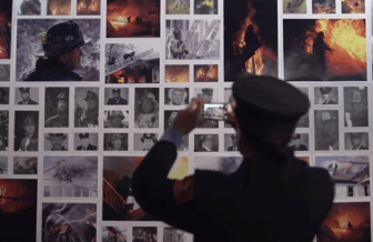 A Boston firefighter photographs a memorial to colleagues who died from cancer.