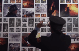 A Boston firefighter photographs a memorial to colleagues  who died from cancer.