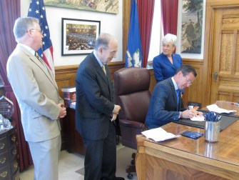 Gov. Dannel P. Malloy signs the budget. From left, House Speaker J. Brendan Sharkey, Senate President Pro Tem Martin M. Looney and Lt. Gov. Nancy Wyman.