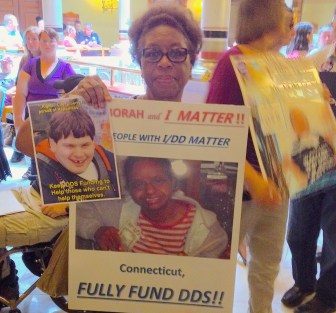 Velma Williams-Estes of Meriden holds a picture of her intellectually disabled daughter Deborah while urging lawmakers Tuesday not to make further cuts to social services in the new state budget.