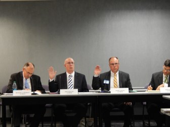 Anthem officials John Bryson, left, and James Augur are sworn in during the rate hearing.