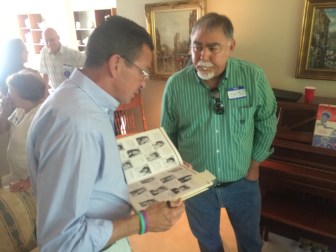 Malloy is shown his high school yearbook by Cris Casey, his opponent for president of the junior class in 1972.