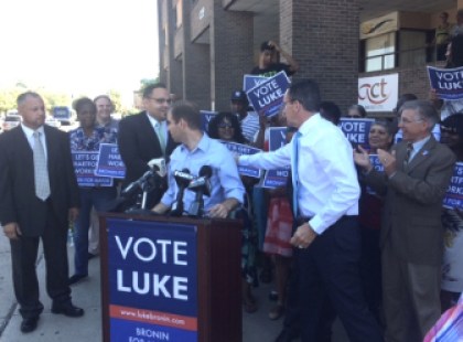 Gov. Dannel P. Malloy reaches behind Luke Bronin to congratulate a member of Bronin's slate.