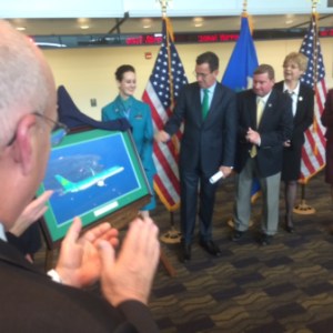 Gov. Dannel P. Malloy watches as Aer Lingues flight attendants unveil a photo marking the airline's symbolic arrival