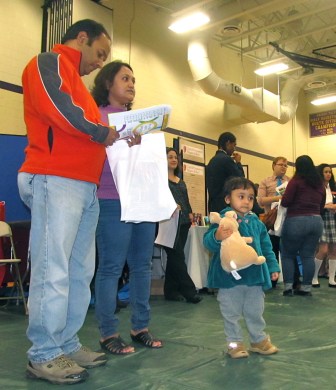 Suhash Ghosh and his wife search for a school for his daughter next year at the School Choice Fair in Hartford