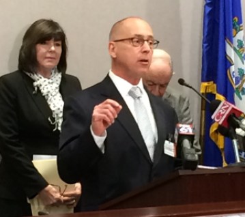 Donald Shubert, president of the Connecticut Construction Industries Association, at podium, and Mary Tomolonius, director of the Connecticut Association for Community Transportation, left, urge support for a transportation lockbox Thursday.
