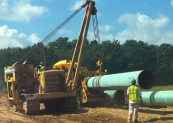 A construction crew prepares to bend a section of 36-inch diameter pipe to follow the contours of the terrain in Cromwell as part of the expansion of the Algonquin natural gas pipeline.