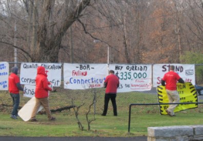 Protesters hang signs along the route regents will walk to get to their monthly meeting.