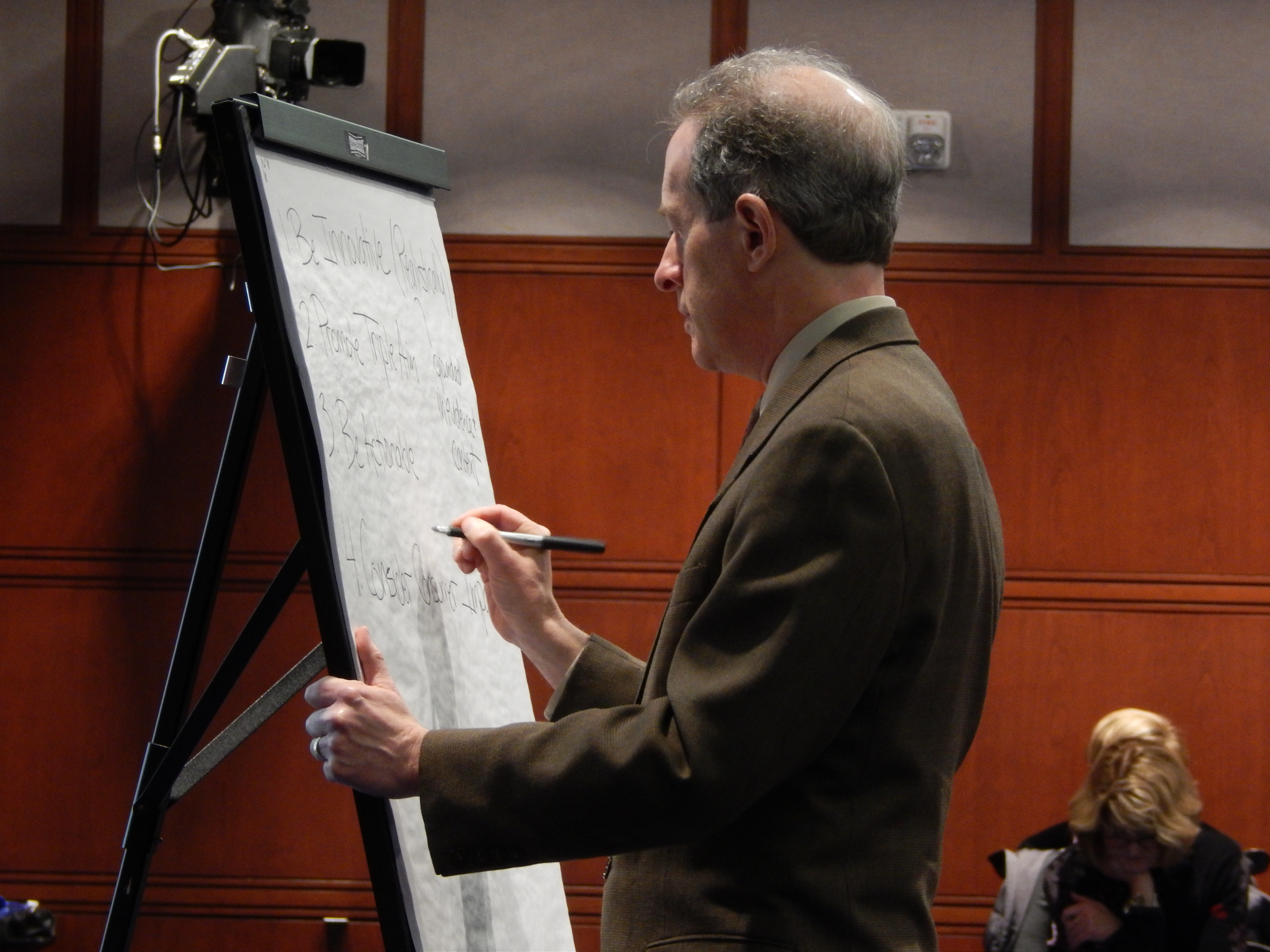 Consultant Michael Bailit takes notes as members of the health care cabinet talk about the study.