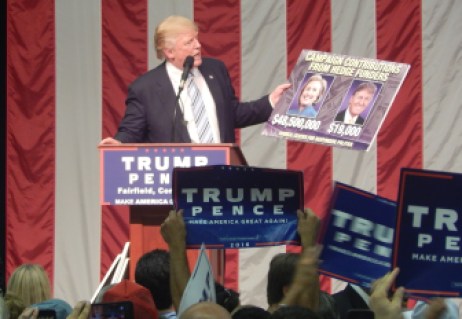 Republican presidential candidate Donald J. Trump holds a sign he said showed how little he had received in contributions from people who work at hedge funds compared to Hillary Clinton.
