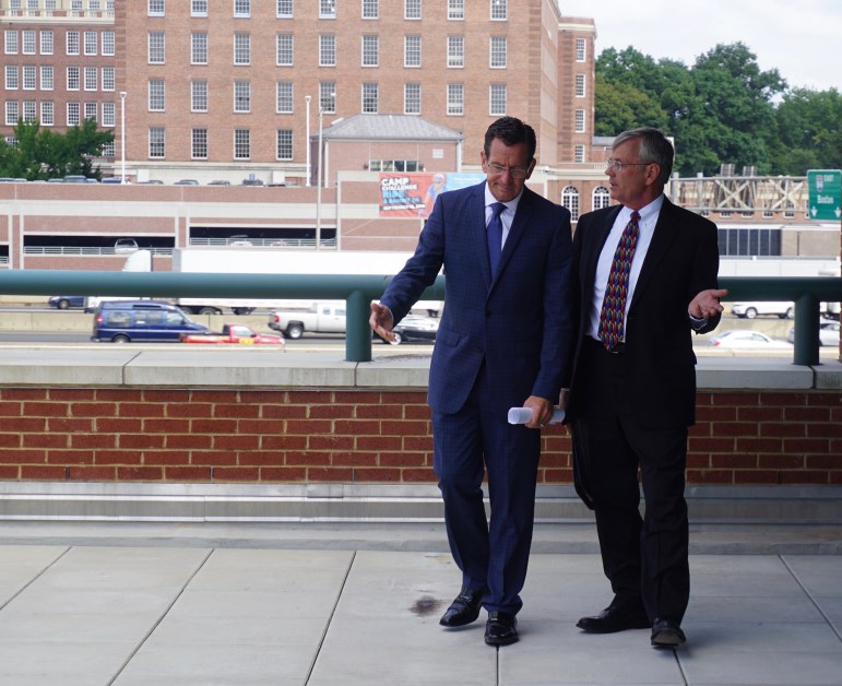 Gov. Dannel P. Malloy and Transportation Commissioner consult before a press conference by the I-84 viaduct.