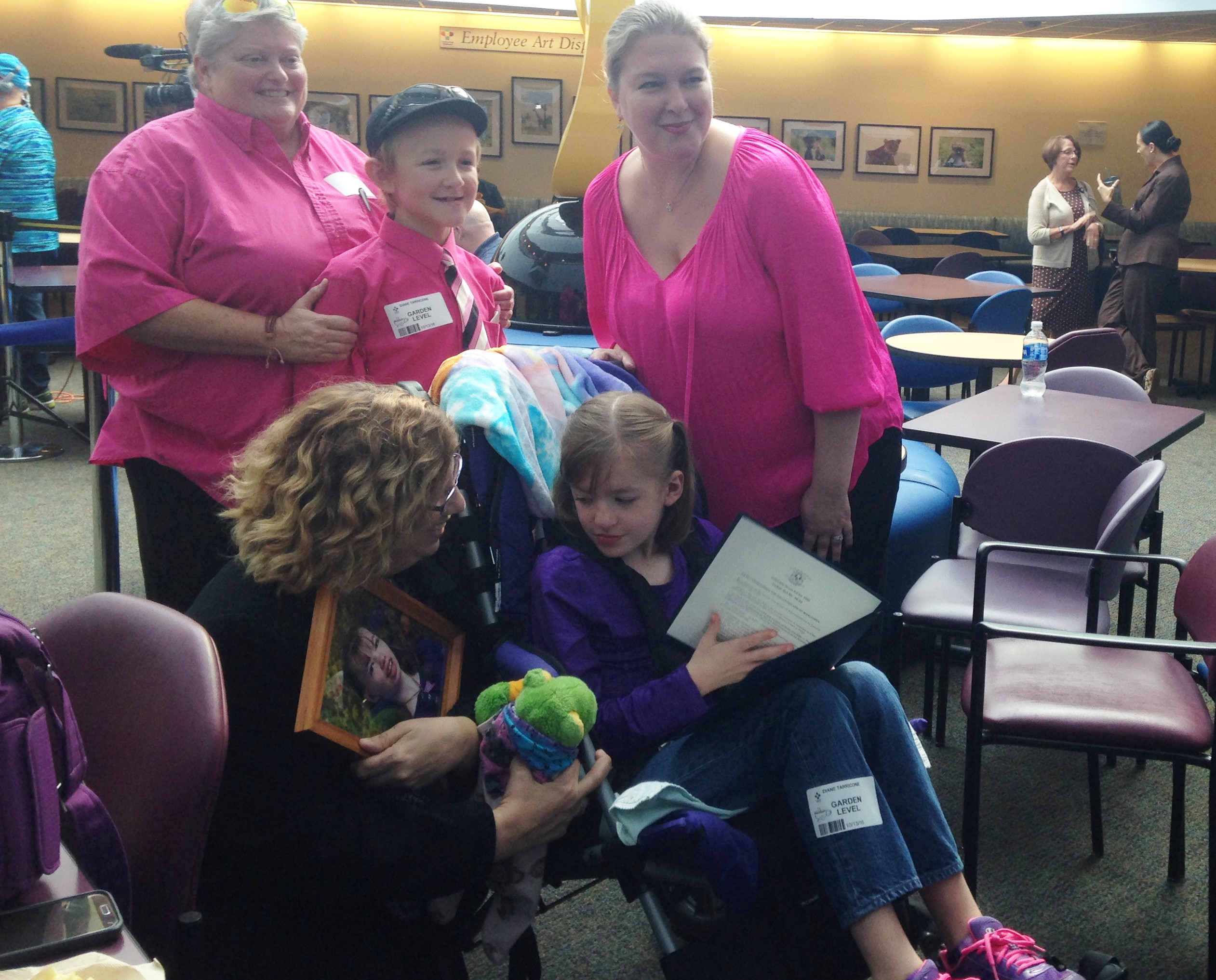 Susan Meehan shows West Tarricone, 8, a photograph of her daughter, Cyndimae, who died in March. Meehan helped inspire the push to legalize medical marijuana for minors in Connecticut. West's parents, Diane and Cara, are applying for West to access it to address her seizures.
