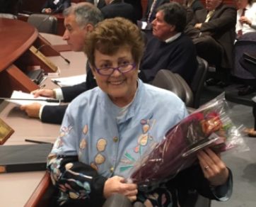 State Rep. Betty Boukus cradles a bouquet of roses at the State Bond Commission meeting Tuesday.