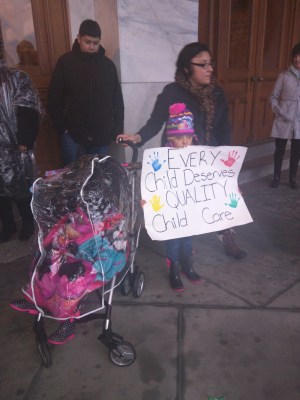 Six year old Janelyn Marquez of New Haven holds up a sign during a rally at the state Capitol about the cuts to the state's child care subsidy program.