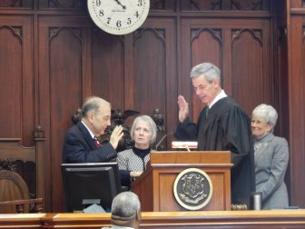 Senate President Pro Tem Martin M. Looney takes the oath of office from Superior Court Judge Brian T. Fischer, a longtime friend who recently donated a kidney to Looney. Looking on is Looney's wife, Ellen.