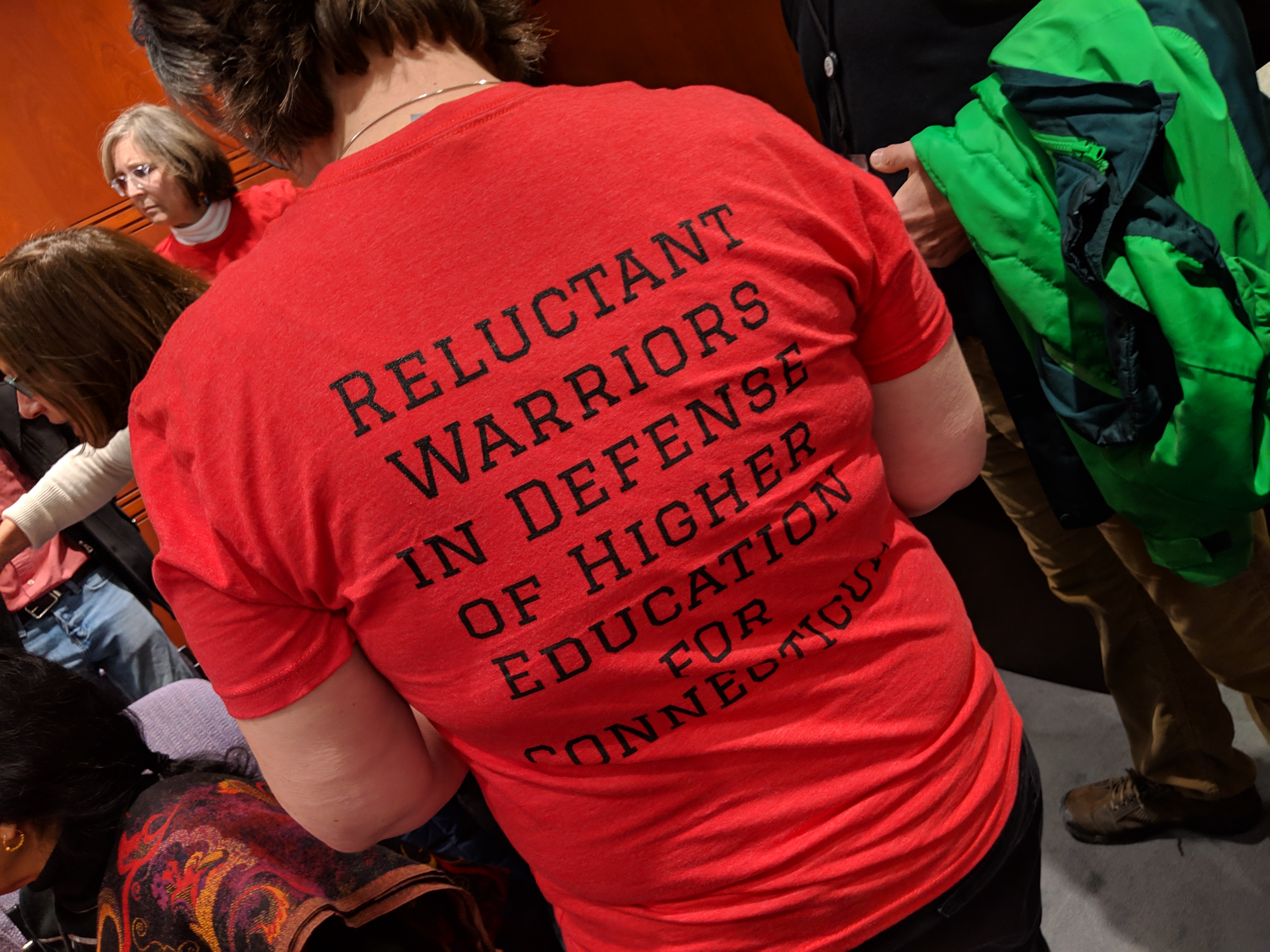 Many of the faculty, including Elle Van Dermark of Asnuntuck Community College, wore red t-shirts calling themselves "reluctant warriors in defense of higher education for Connecticut."