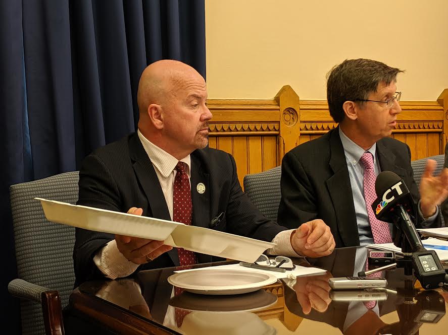 Rep. Joseph Gresko told reporters Tuesday that House Democrats are no longer using containers made of Styrofoam for events. He holds up a container made of pressed sugarcane that the legislators are using instead. Rep., Mike Demicco, co-chairman of the environment committee is at his right.