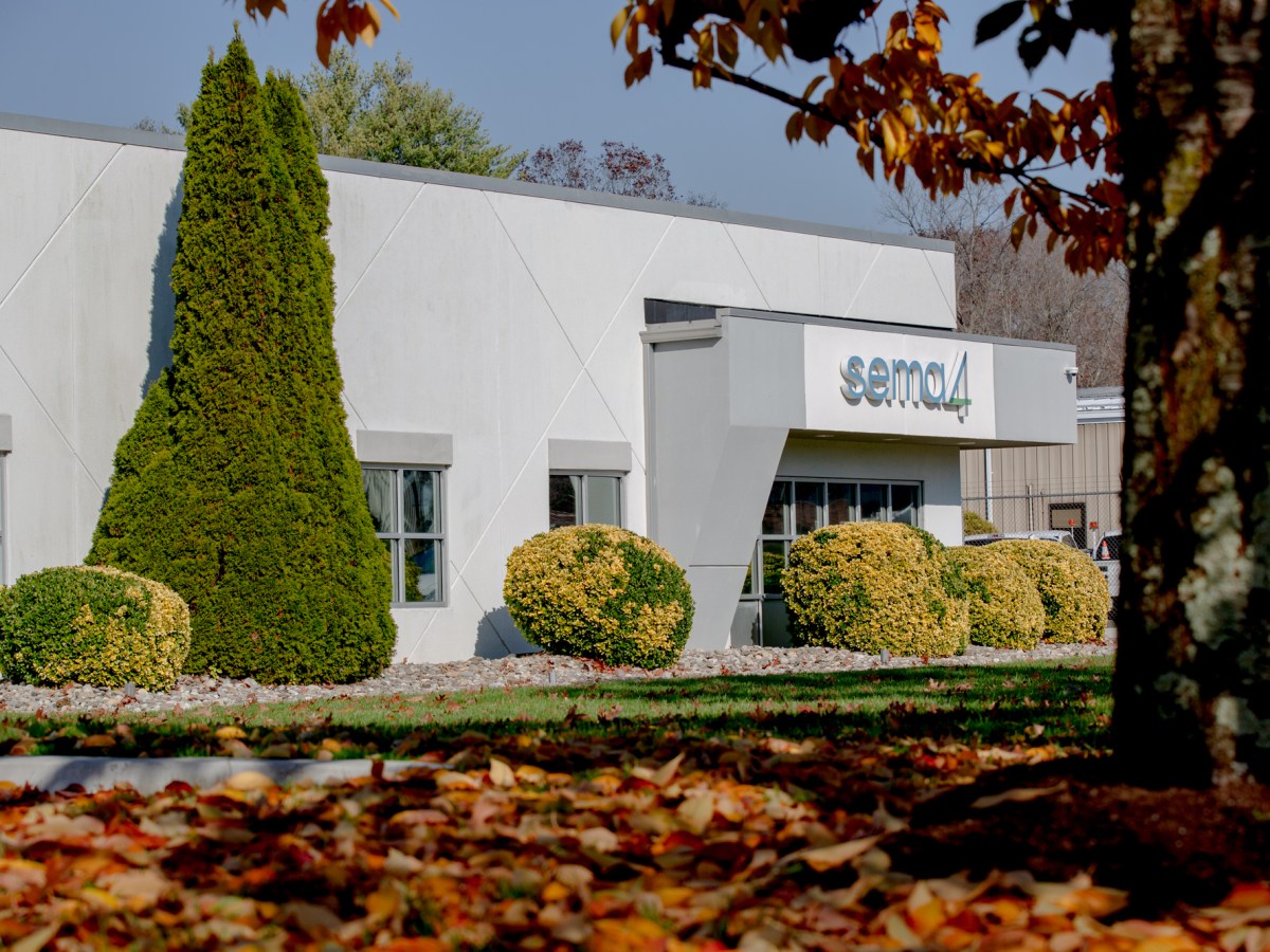 The outside of an office building with trees and bushes.