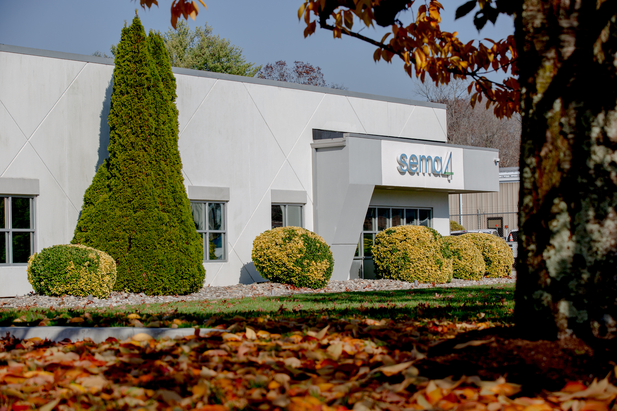 The outside of an office building with trees and bushes.