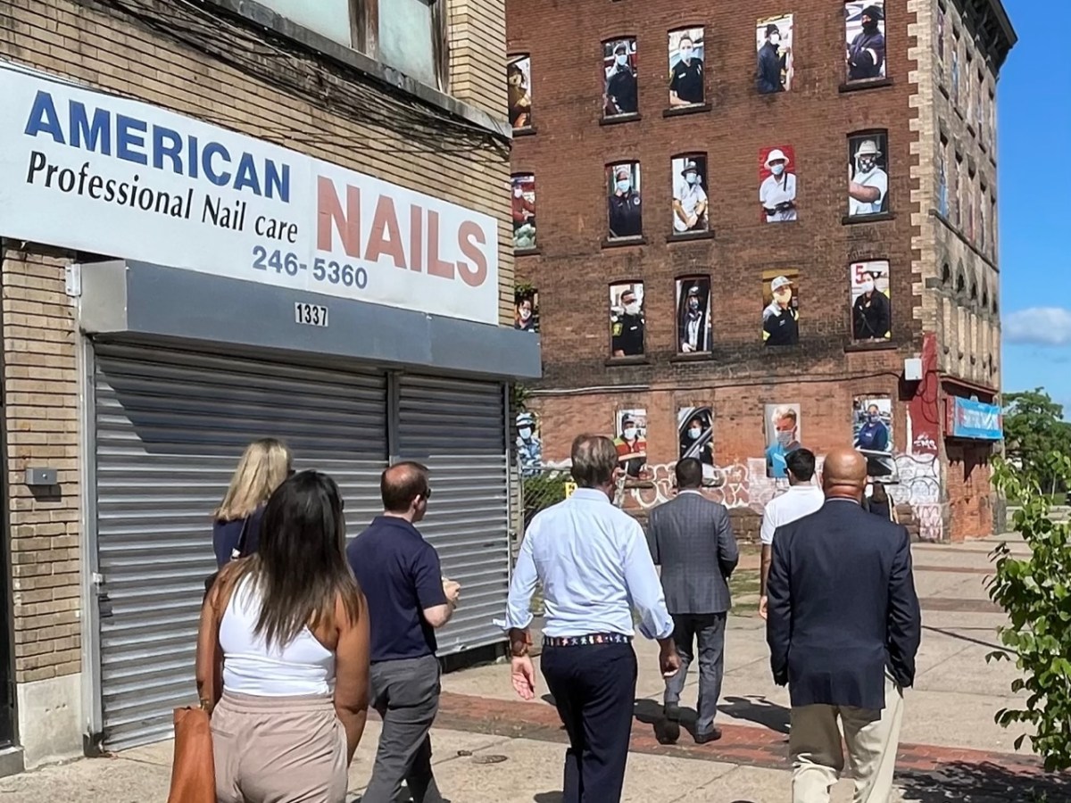 City and state officials walk past a storefront in Hartford.