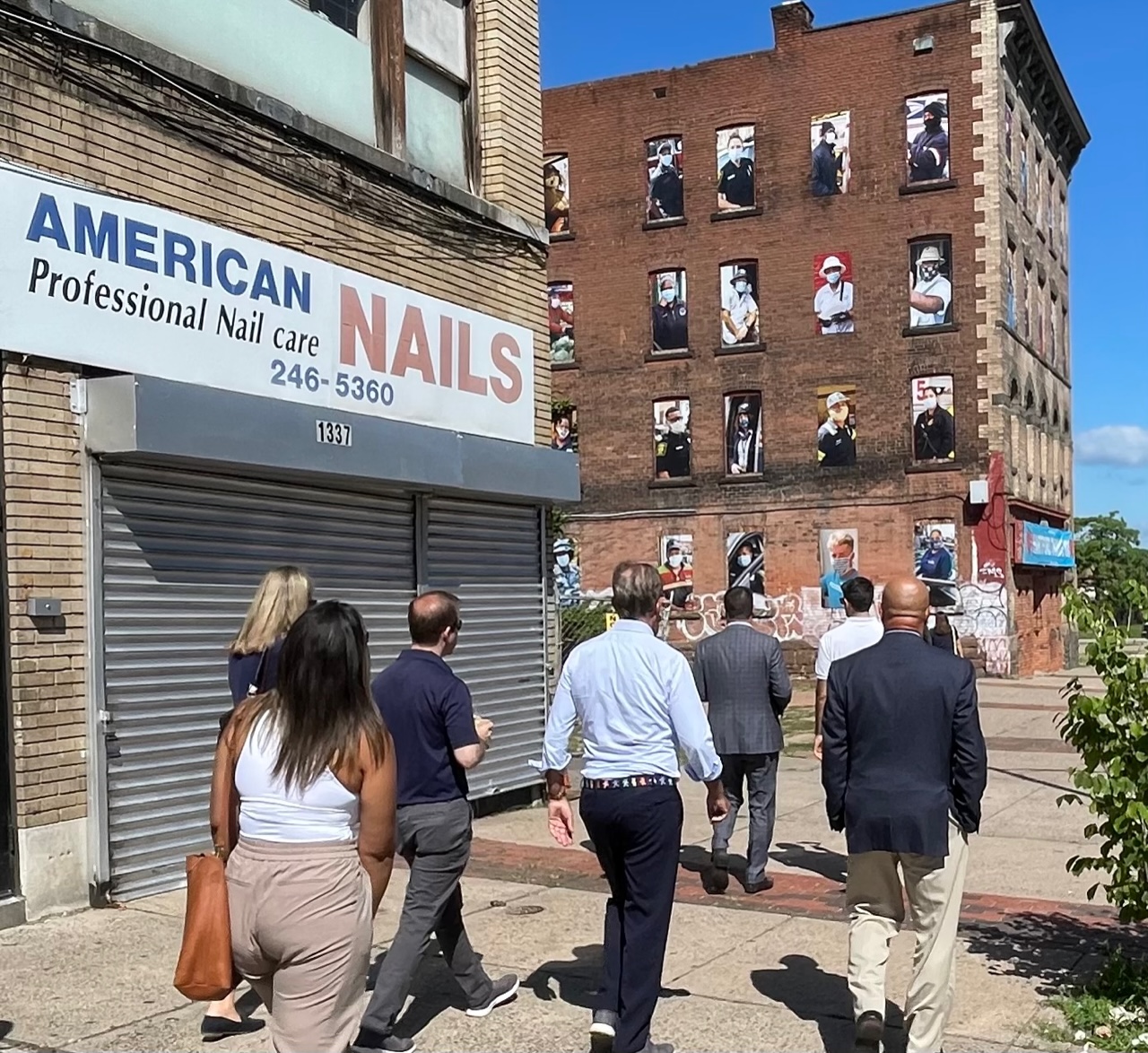 City and state officials walk past a storefront in Hartford.