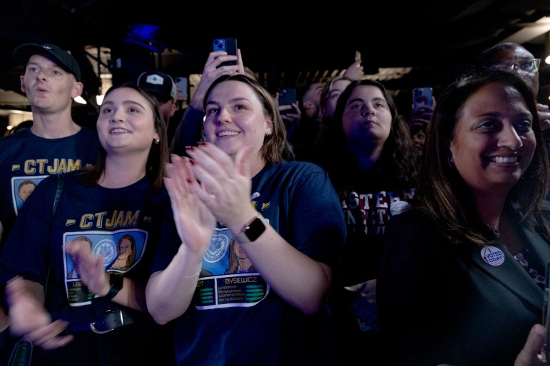 Un grupo de personas aplaudiendo y gritando en apoyo.