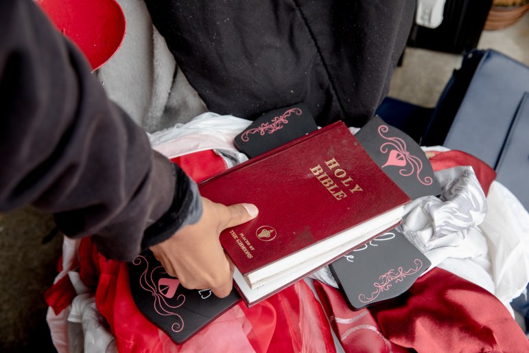 La mano de una mujer sostiene una copia roja de la Santa Biblia.