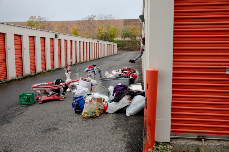 Bolsas de basura, muebles y cajas se encuentran fuera de una unidad de almacenamiento.