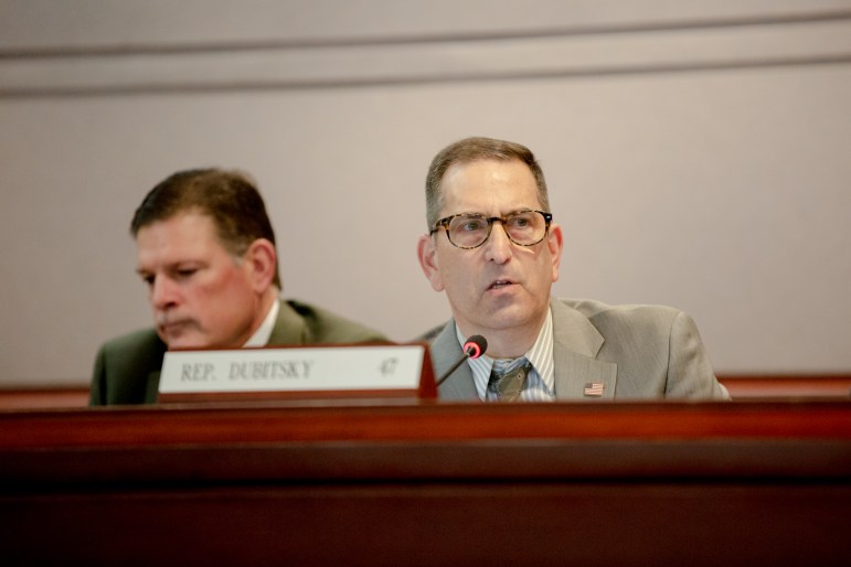 State Rep. Doug Dubitsky is seen talking into a microphone as he attends a meeting.