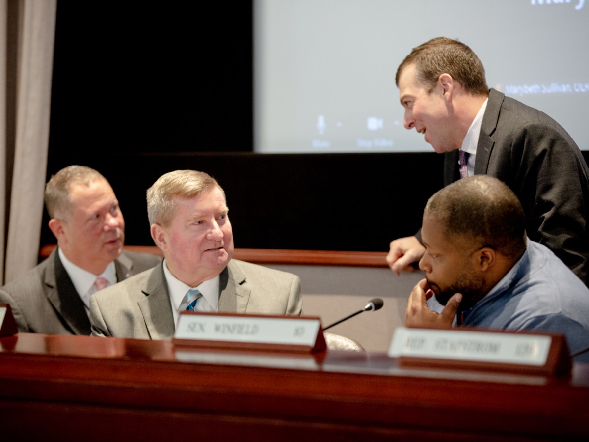Craig Fishbein, John Kissel, Steven Stafstrom and Gary Winfield sit in a room in Hartford's Legislative Office Building, conversing after a meeting.